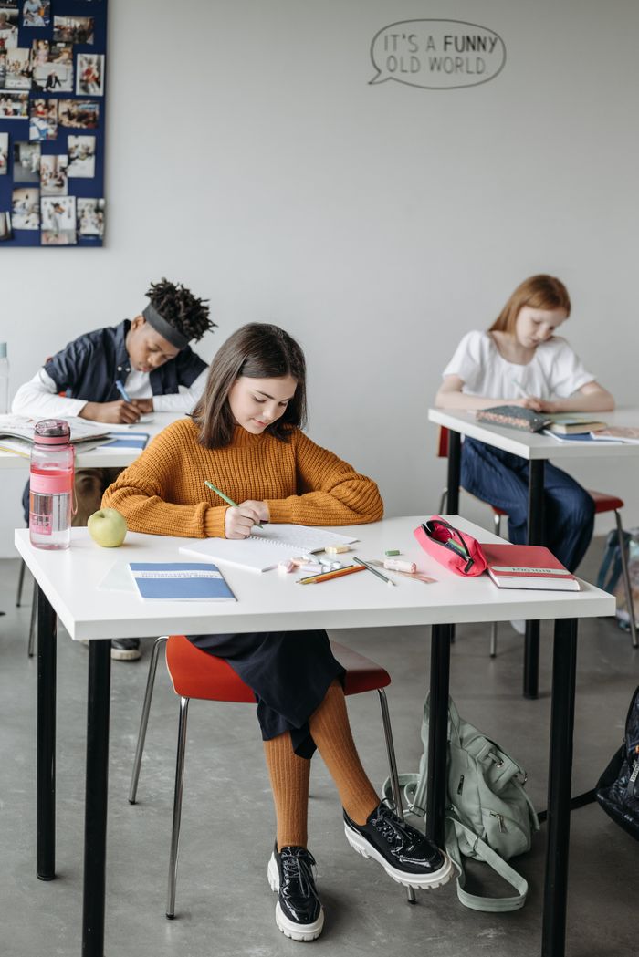 Teenagers focused on learning in a modern classroom environment.